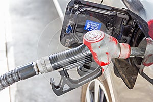 Men hold Fuel nozzle to add fuel in car