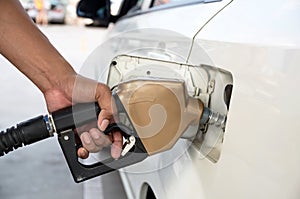 Men hold Fuel nozzle to add fuel in car at filling station