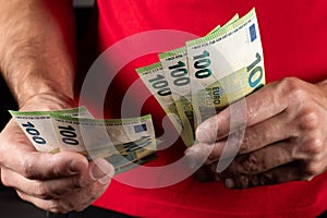 Men hold hundred euro bill in his hands, pay with euros, poverty in europe, no cashless paying