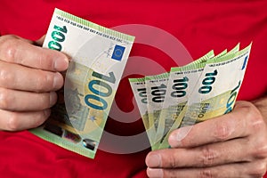 Men hold hundred euro bill in his hands, pay with euros, poverty in europe, no cashless paying