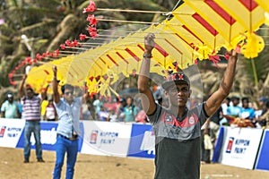 Men hold up sections of a Japanese kite on Negombo beach in Sri Lanka.