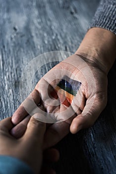 Men holding hands and rainbow flag