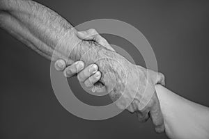 Men holding hands together on grey background