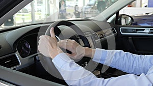 Men holds steering wheel inside car, man`s hands at helm, fortunate