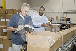 Men Inspecting Goods In Warehouse