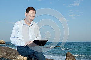 Men with laptop on the beach