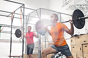 Men lifting barbells in crossfit gym