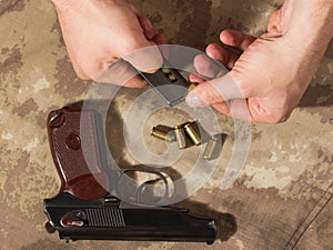 Men load ammo in the clip Makarov pistol