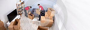 Men Loading The Cardboard Boxes During Moving