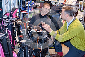 Men looking at golfing equipment in store