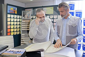 men looking at wallpaper samples