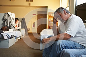 Men Lying On Beds In Homeless Shelter photo