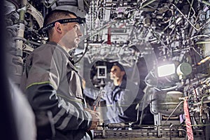 Men mechanics is working inside the airplane