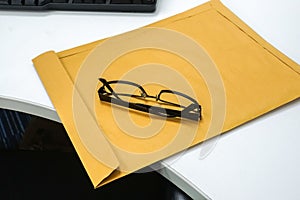 Men modern eyeglasses on brown confidential envelope