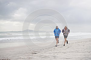 Men, ocean and running on beach, sand and fitness for wellness and gym wear on coast together. Male athletes, jog and