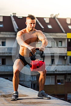 Men performing squats with shoulder raise on the rooftop