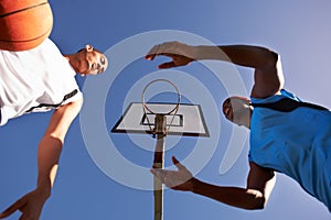 Men, player and basketball match at outdoor court or low angle of challenge team, dunk on rival. Male people, hoop and