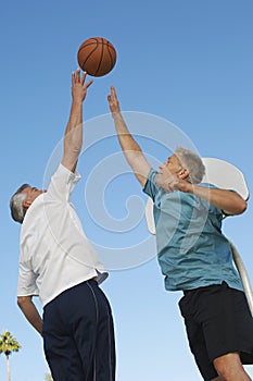 Men Playing Basketball Against Blue Sky