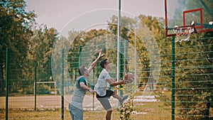 Men playing basketball on the sports ground outdoors