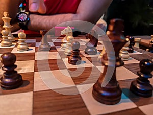 Men playing chess - King and chess pieces on a wooden board