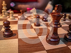 Men playing chess - King and chess pieces on a wooden board