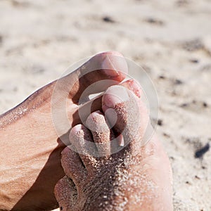 Men playing footsie on the beach