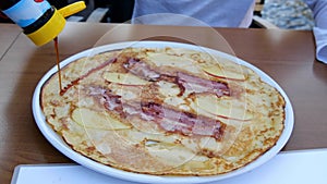 Men pouring pancake with sweet sauce