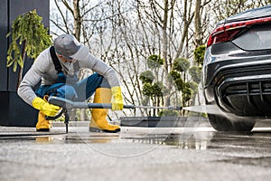 Men Pressure Washing His Car in Front of a House