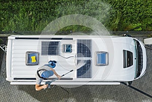 Men Pressure Washing RV Camper Van Roof Equipped with Solar Panels