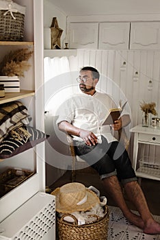 Men reading book in trailer, traveling in camper motor home