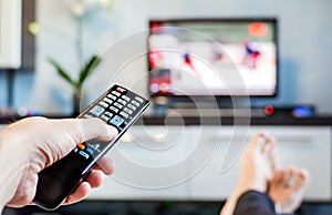 Men with the remote control, front of the television. photo