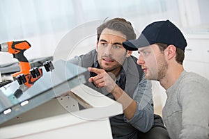 men renovating kitchen and using cordless drill photo