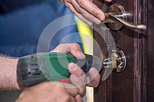 Men repairing a door using a drill