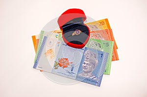 Men ring inside red box with Malaysian currency notes