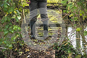 Men in rubber boots on the rustic wooden bridge