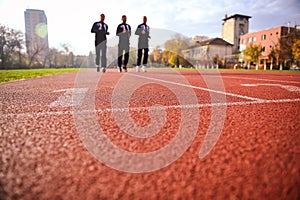 Men running on athletics track lanes