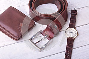 Men`s accessories for business and rekreation. Leather belt, wallet, watch and smoking pipe on wood background.. Top