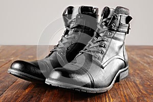 Men`s army boots on wooden table