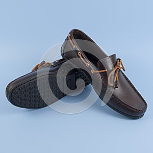 Men`s brown moccasins, loafers isolated on blue background