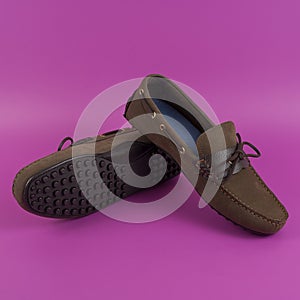 Men`s brown moccasins, loafers isolated on pink background