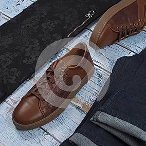 Men`s casual outfits for man clothing set with shoes, trousers, shirt on wooden background, Top view