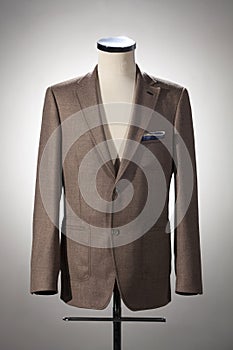Men`s clothing, brown jacket on stand. Isolated on white background