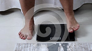 men's feet stand on the scales weight control