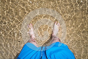 Men`s feet in the water