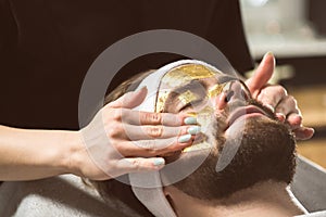 Men`s gold mask therapy at beautician`s