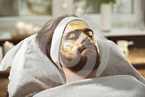 Men`s gold mask therapy at beautician`s