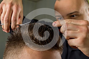 Men's hair cutting with scissors in a beauty salon