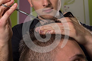 Men's hair cutting with scissors in a beauty salon