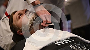 Men`s hairstyling and haircutting in a barber shop or hair salon. Grooming the beard. Barbershop. Man hairdresser doing