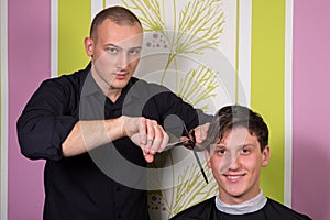 Men's hairstyling and haircutting with hair clipper and scissor